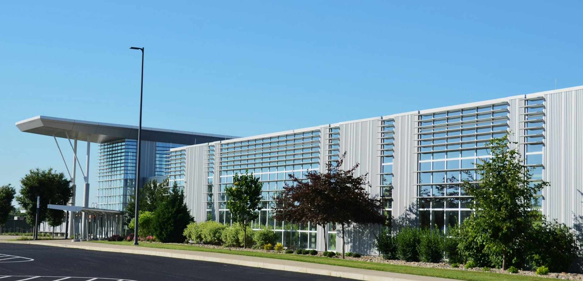 A modern commercial building entrance with a landscaped approach