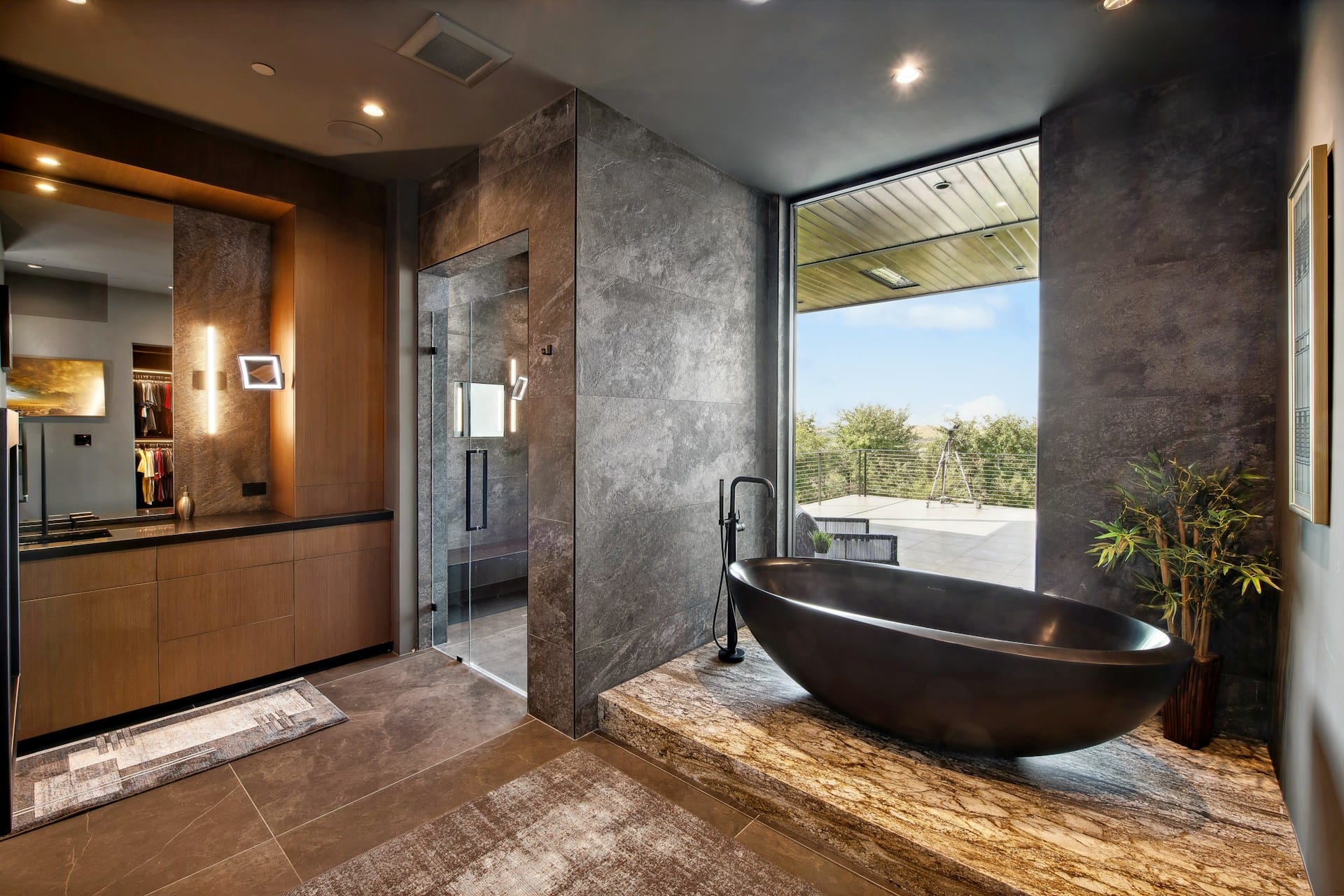 A restrained modern primary bathroom with a natural stone freestanding tub